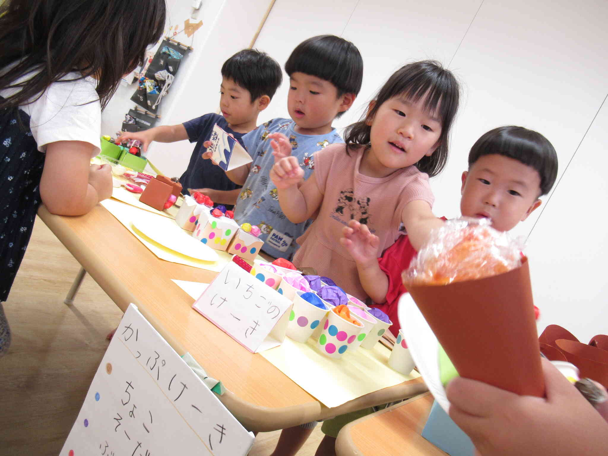 ここはカップケーキ屋さんです。「どの味がいい？おすすめはね、ソーダですよ♪」ソーダのカップケーキ？？シュワシュワするのかなぁ？甘くておいしそうだね。このカップケーキはぱんだぐみさんたちの手作りです。カップのまわりにもかわいい模様が付いています。