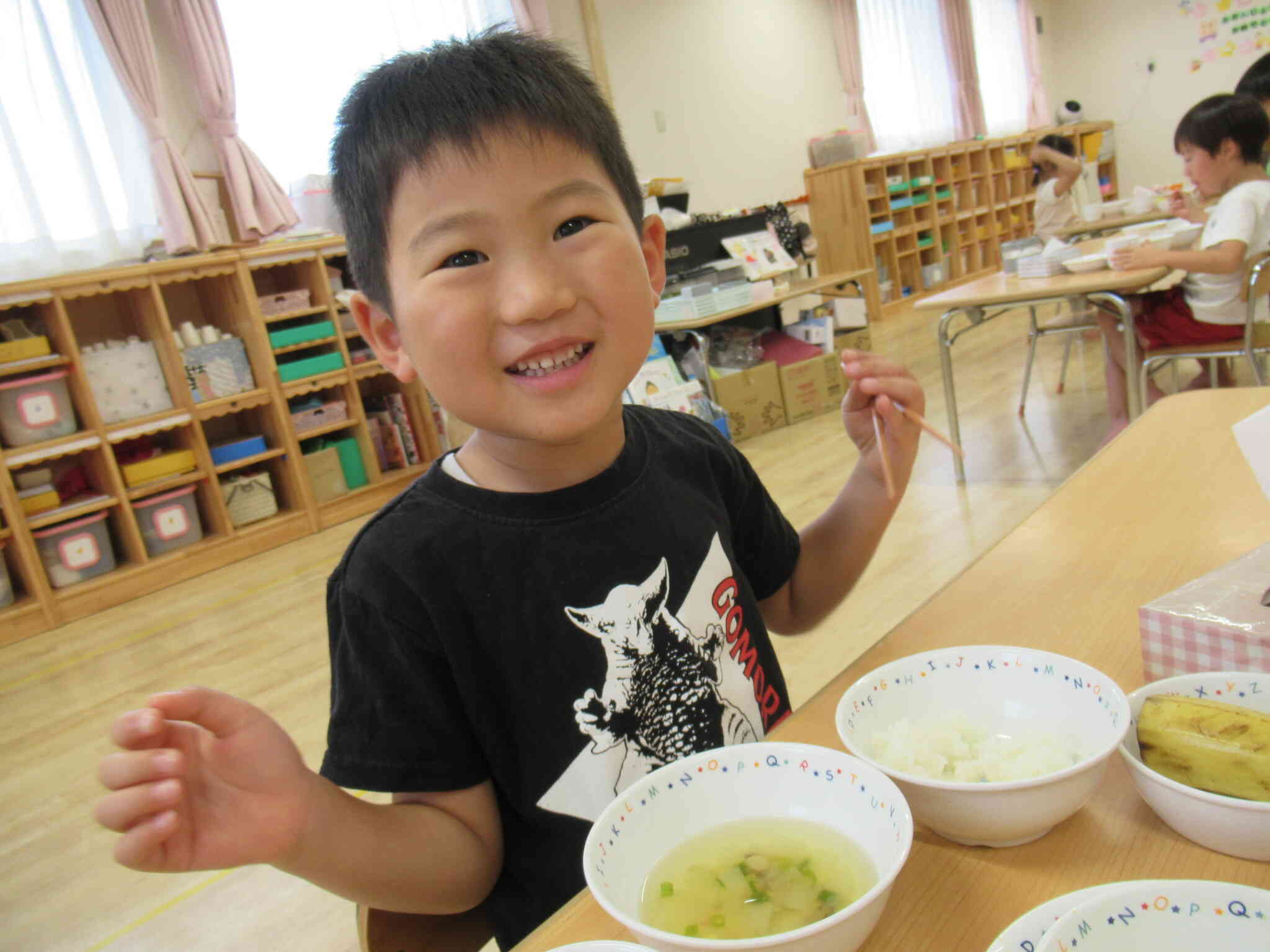 「ママ、みてみて。今日の給食はこれだったよ。」「うわぁ。すごくおいしそう！」お迎えに来る保護者の方に給食の献立についてお話する子どもたちも多いんですよ。事務室前にはその日の給食のサンプルを飾っています。