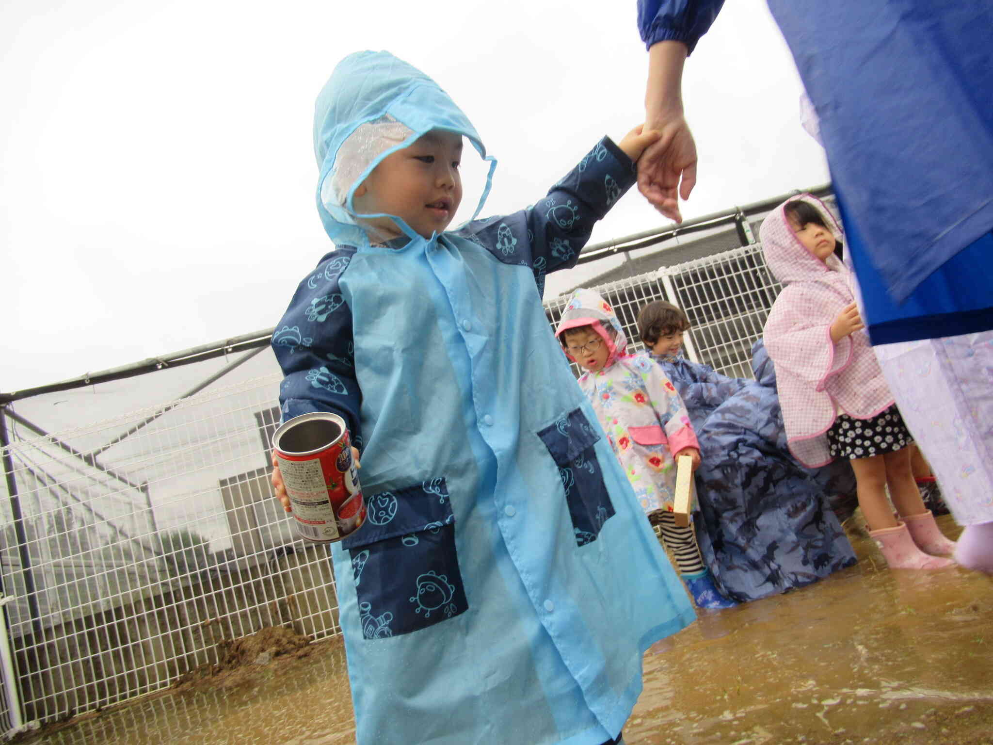 雨の日の園庭って初めてだね。先生と手をつないで一緒に歩いてみたよ。大きな水たまりもあるね！ちょっと入ってみようかな♡バシャバシャ・・・