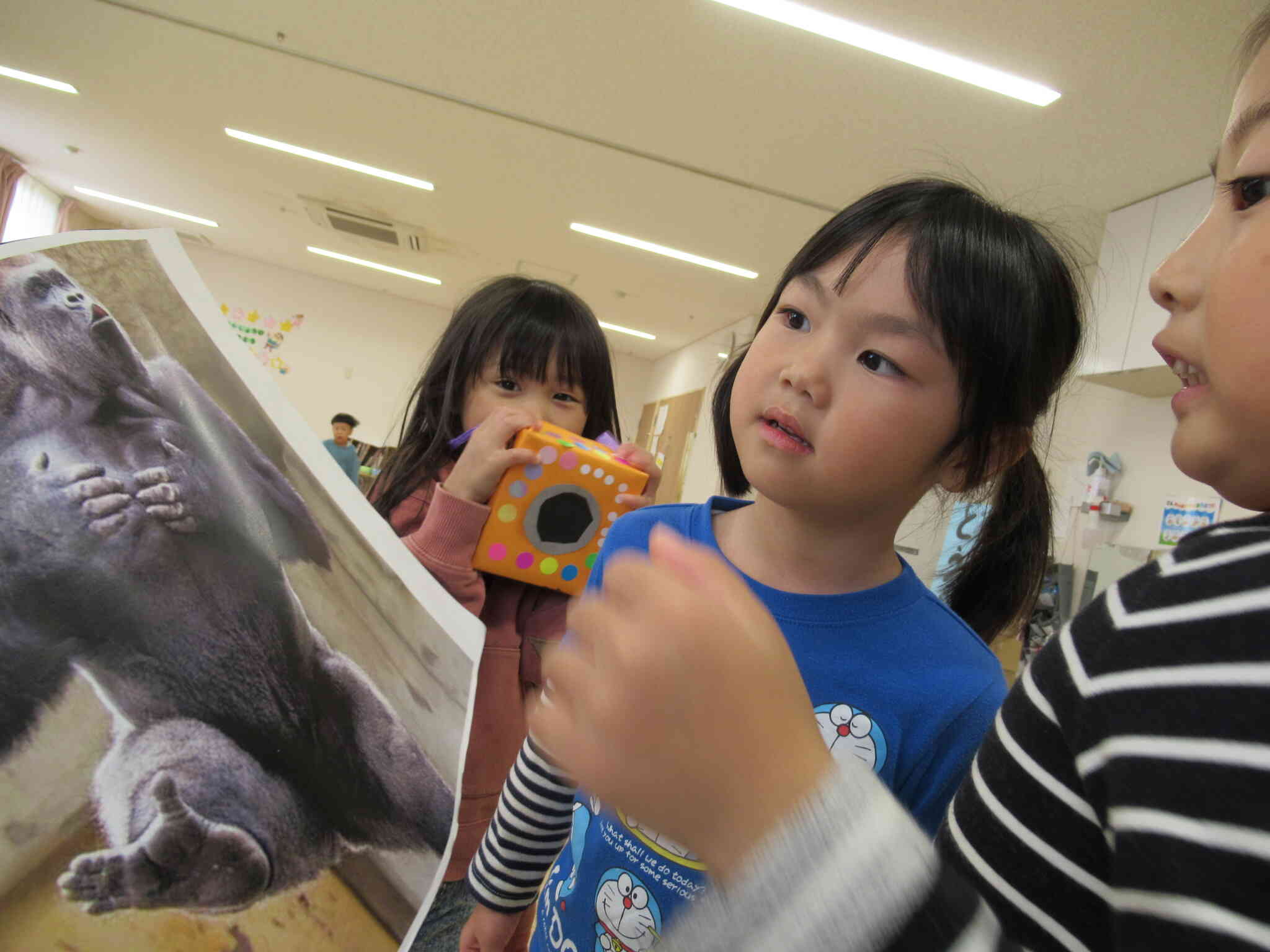 わたしにも見せて～。みんなでゴリラの真似をどうやってしたらいいのか考え中。ゴリラの顔っておもしろいね！ウッホウッホ！ほら、あっちに仲良しなゴリラさんがいるよ、見に行ってみよう！！