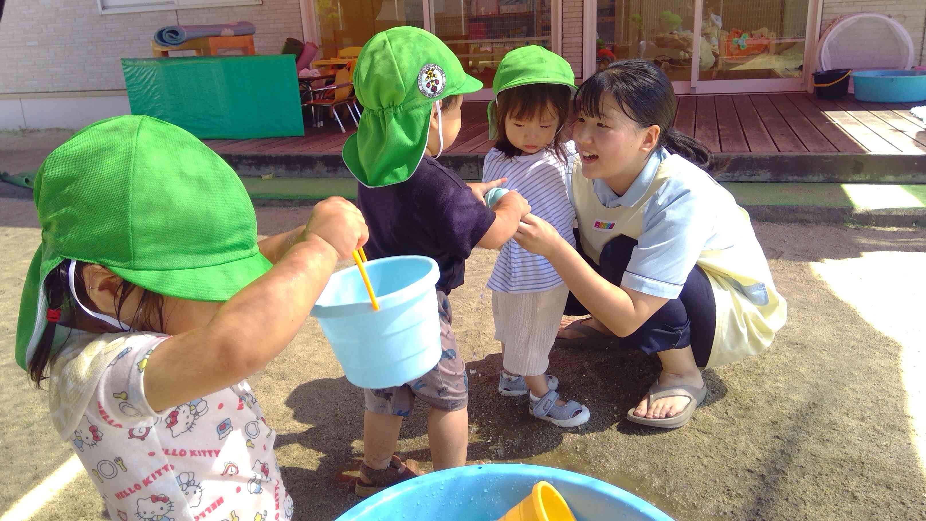 慣らし保育中のおともだちに「あーそーぼー」みずでっぽうを見せてあげる優しいおともだち。