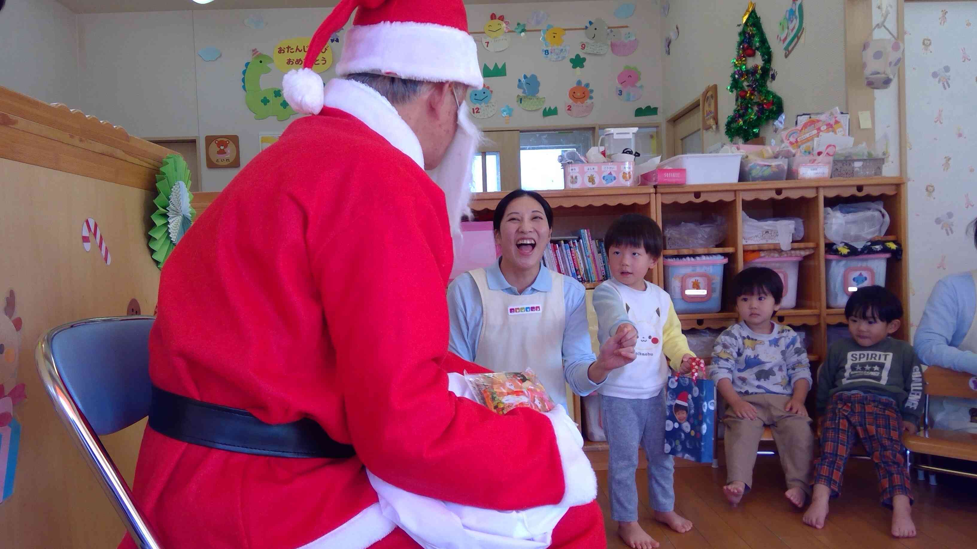 憧れのサンタさんに会えて、ちょっぴり恥ずかしくて保育者の後ろに隠れちゃいましたよ。