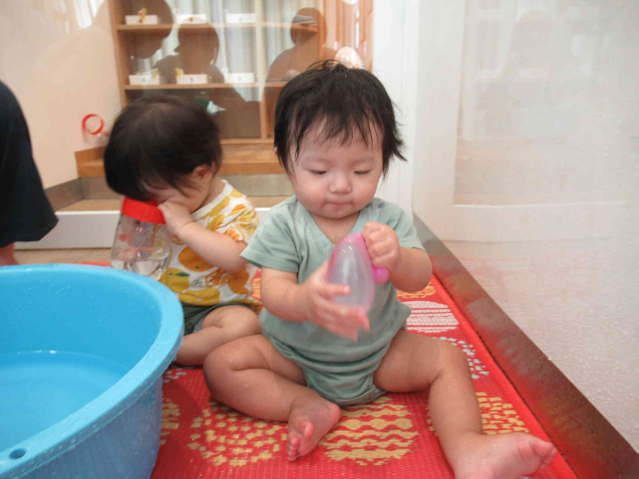 お水を覗いてみている子と、水風船を触って楽しむ子がいますね♡