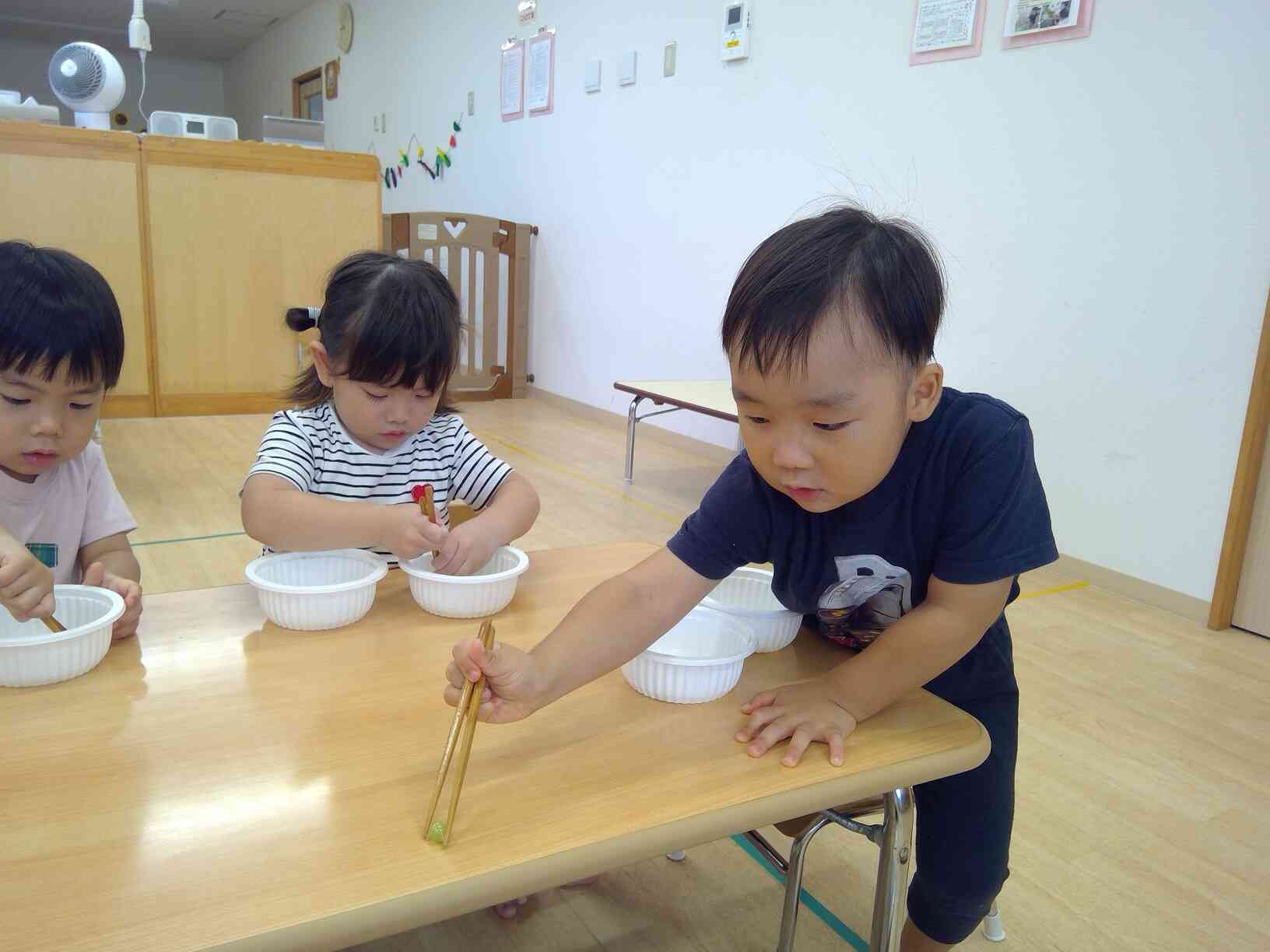 お箸に挑戦しています。　うさぎ組（2歳児）