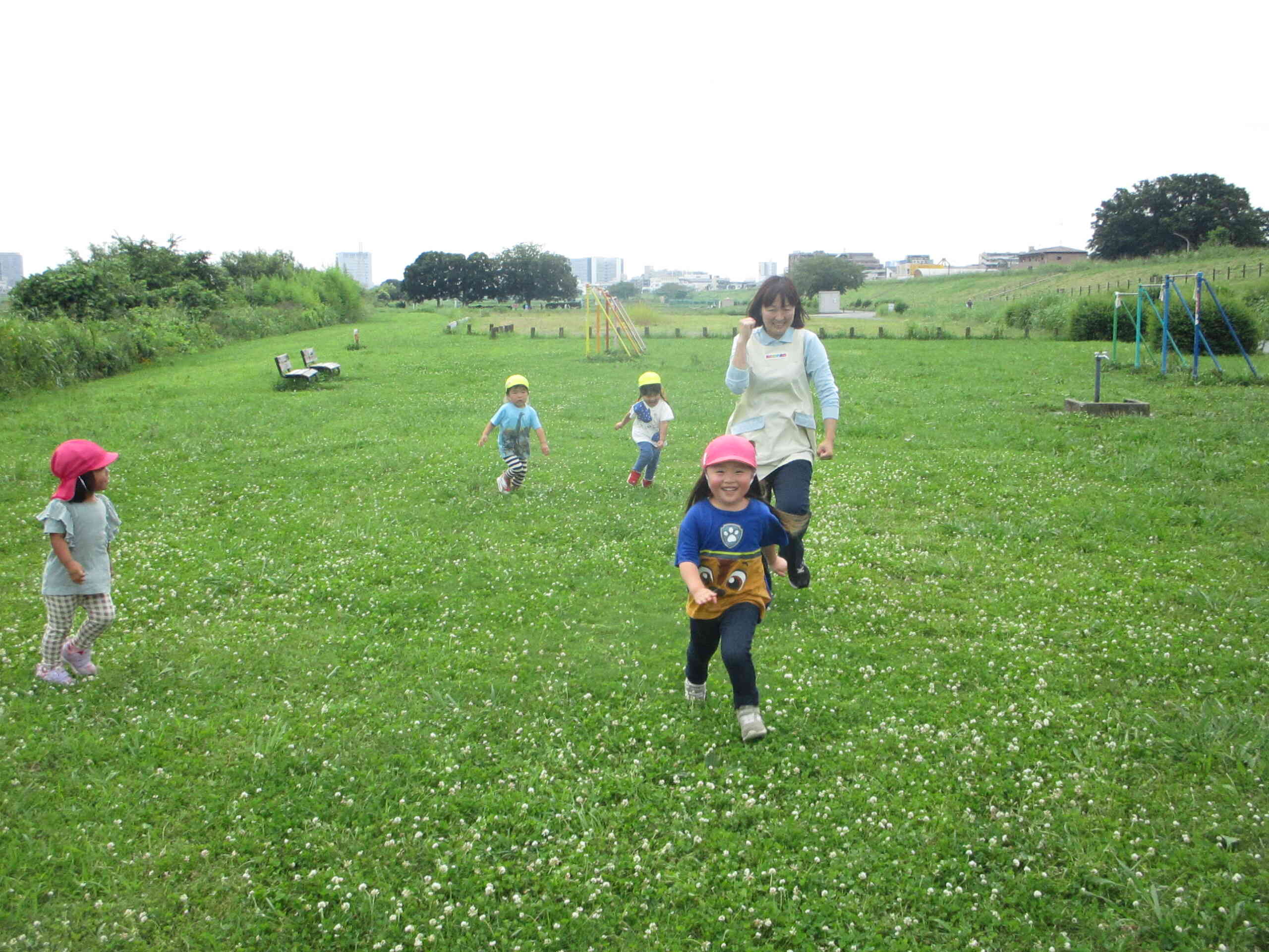 おもいっきりかけっこ～　2、3歳児クラスで散歩に行きました。　ひろ～い広場でおもいっきりかけっこをして楽しみました。