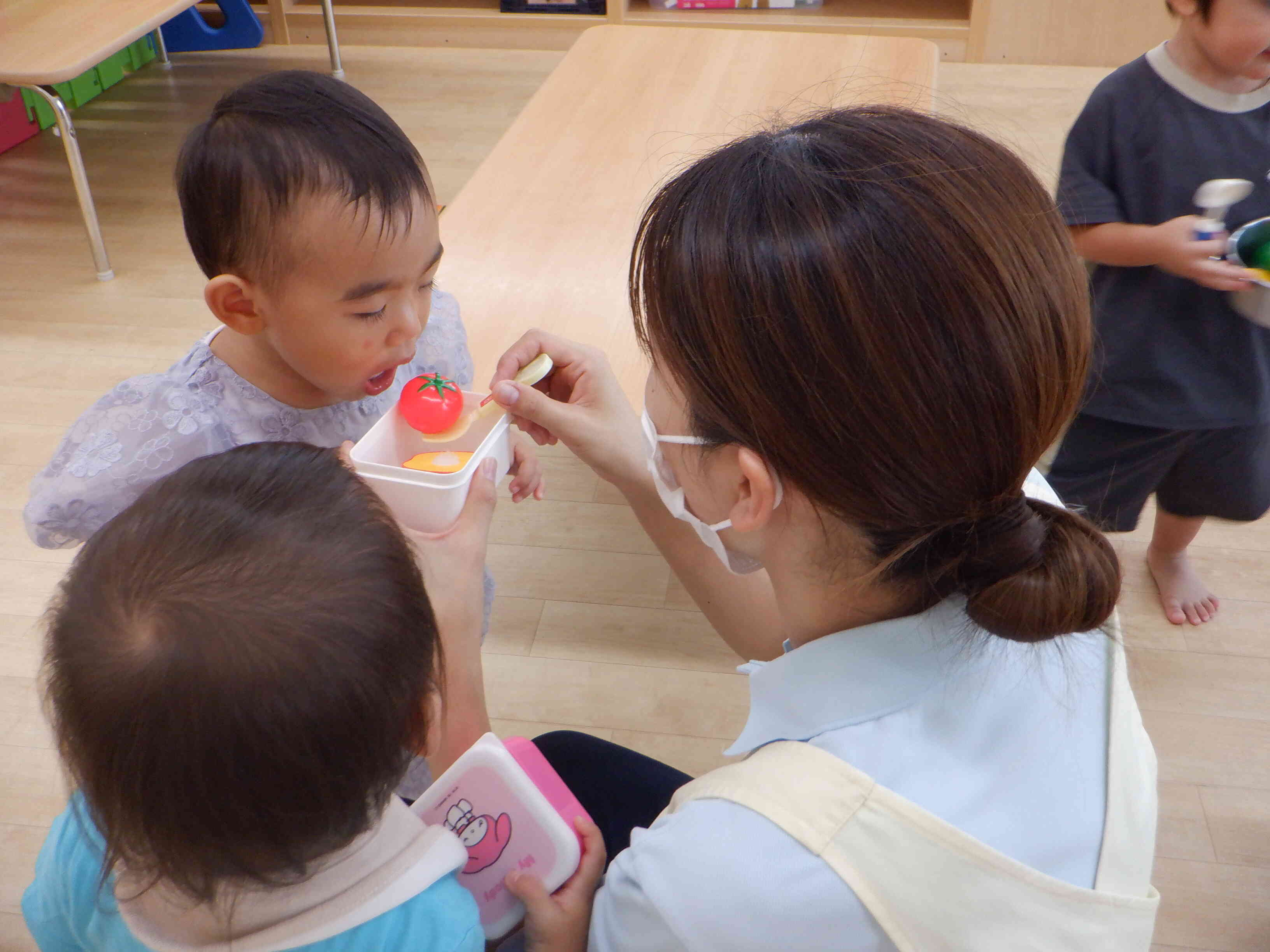 「食べさせて～」おままごとでの場面。みんな大好き、保育者とのゆったりとした遊びの時間です。