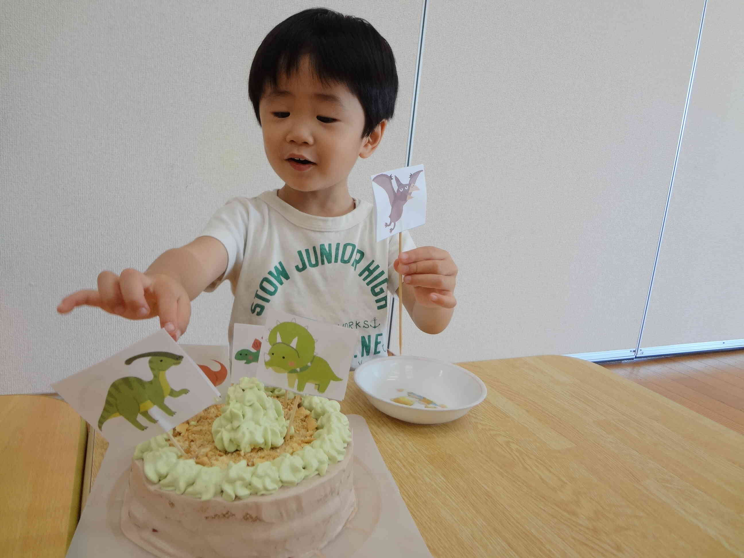 そして今日のおやつは僕の大好きな「恐竜」のケーキを給食先生がつくってくれたよ！E君もニコニコです！