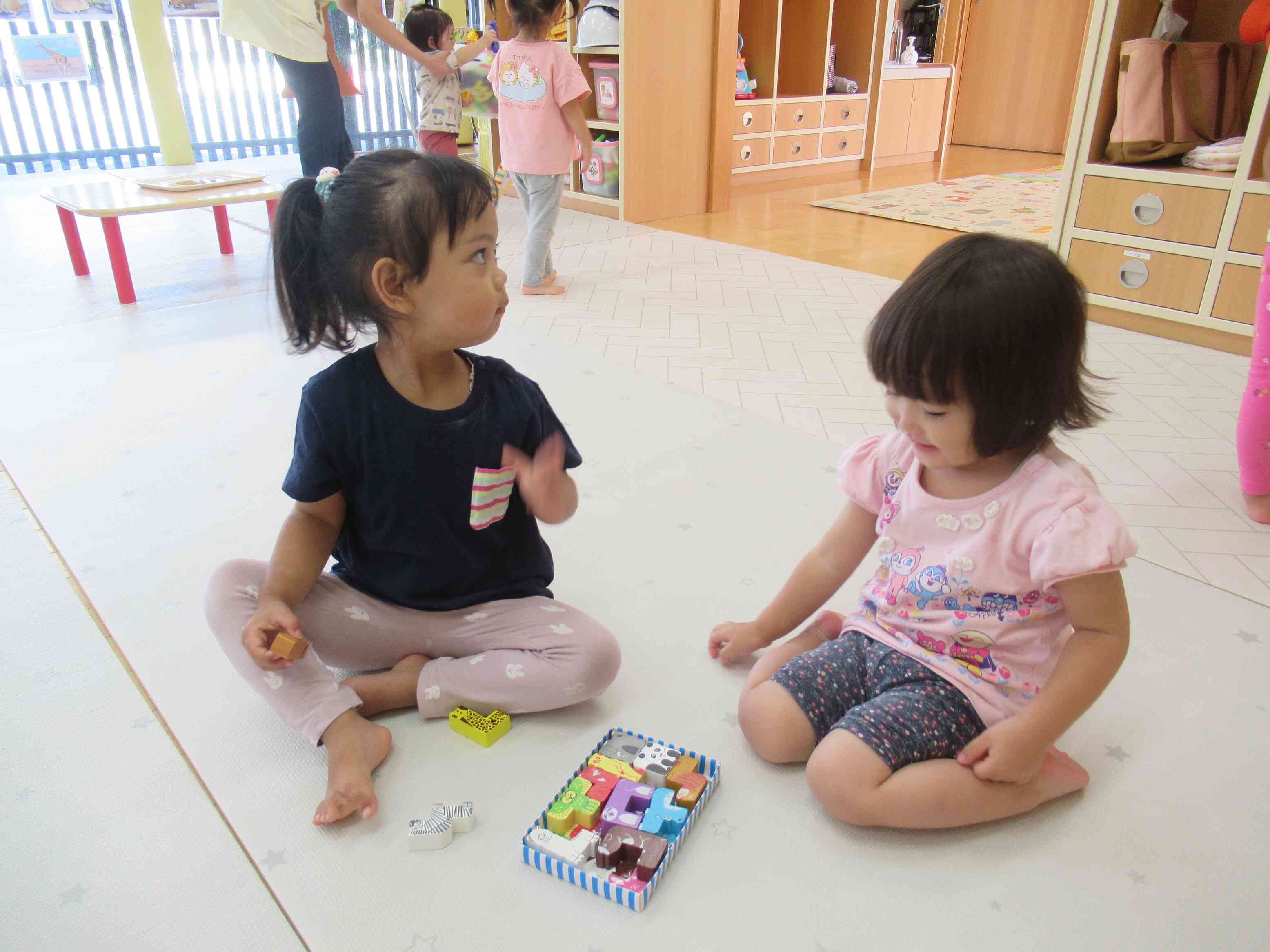 １歳児さんと２歳児さんは、いっしょに動物パズルで遊んでいます。