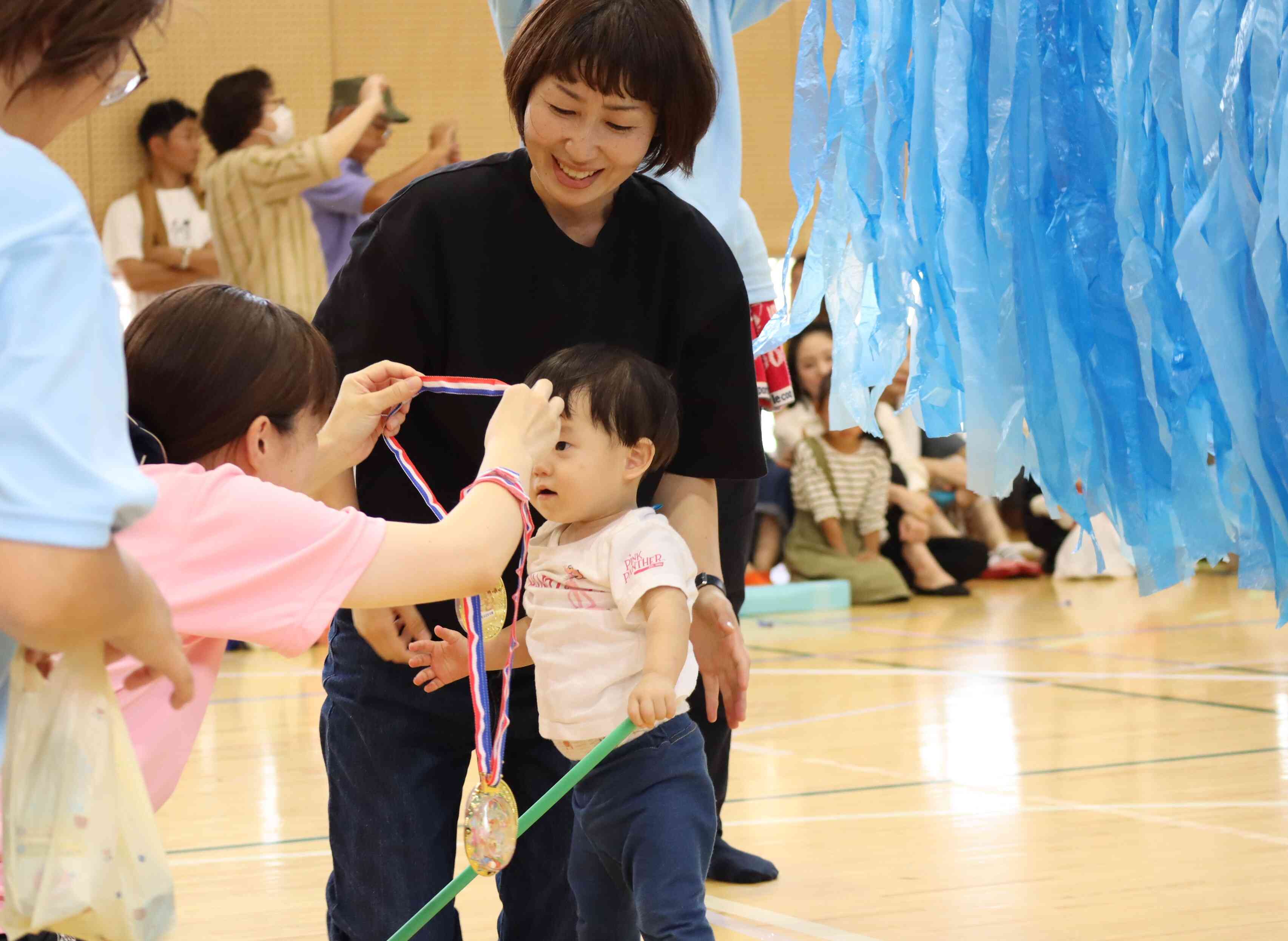 ０歳児さん親子競技のゴール。頑張ったねって、先生にメダルをもらったよ。