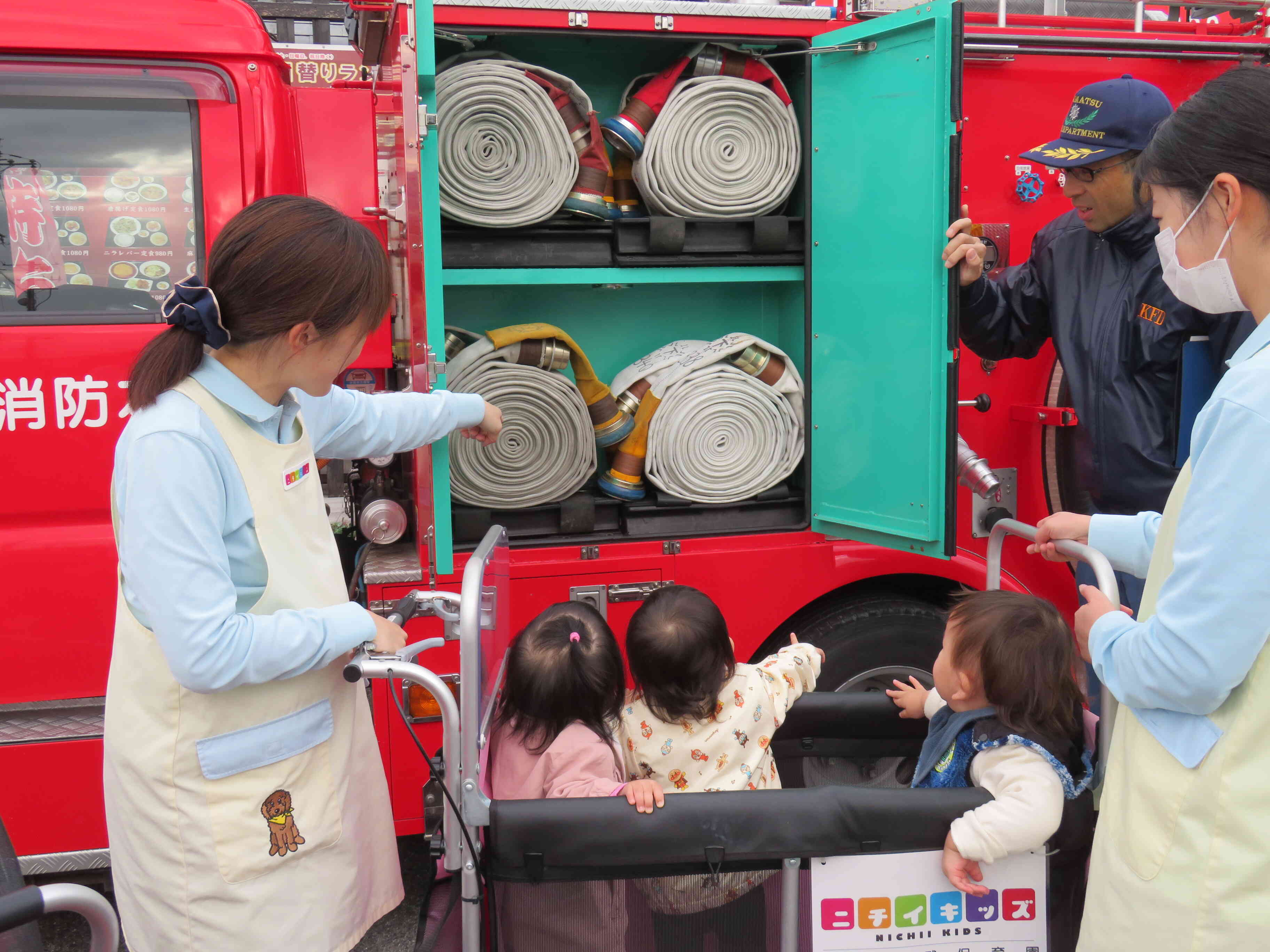 消防車には扉やレバーがいっぱい。扉を開けて見せてくださいました。みんな興味津々の様子。