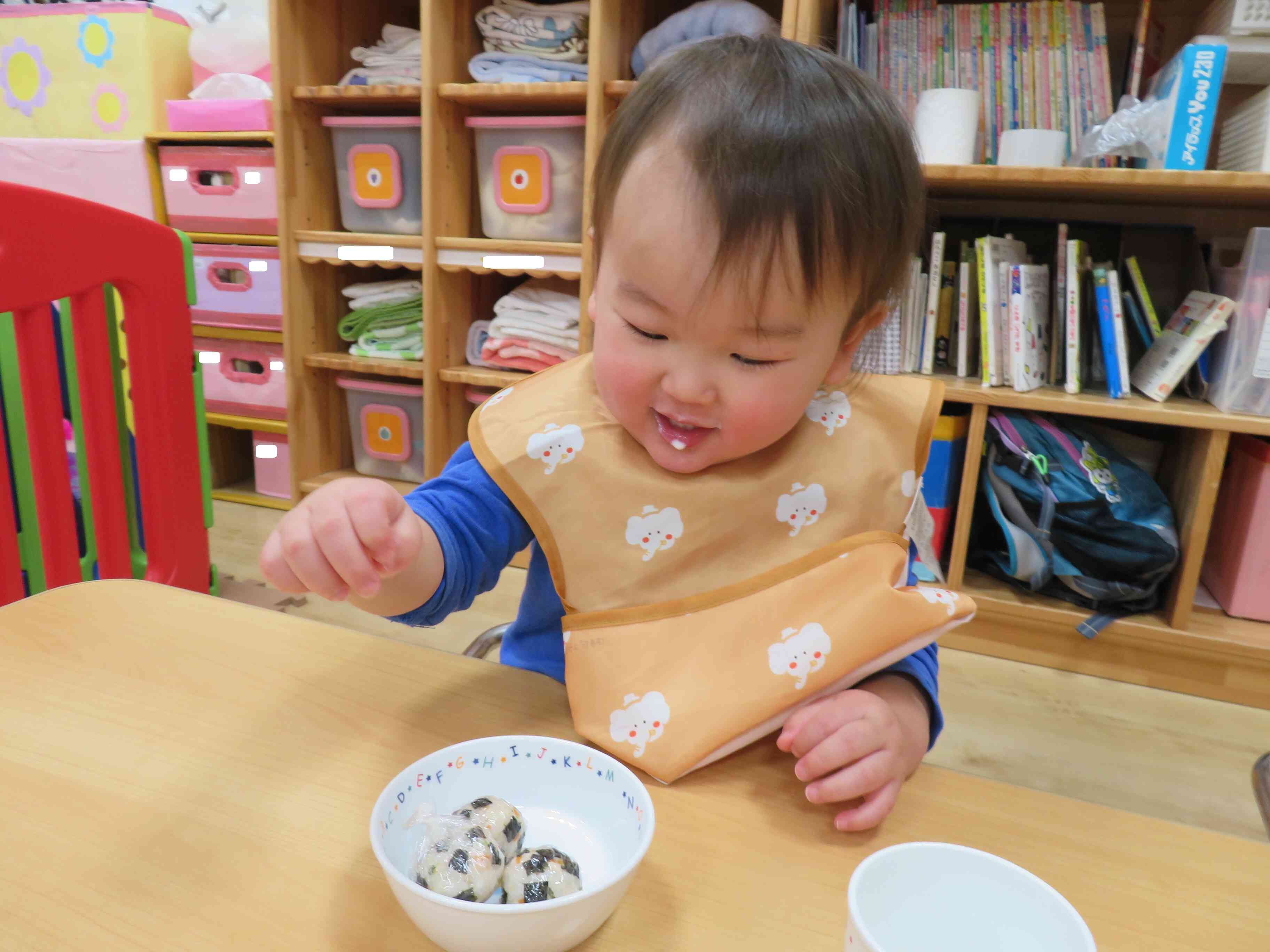 0歳児さんはラップに包んだ恵方巻おにぎりを、にぎにぎ握って・・・いただきま～す！