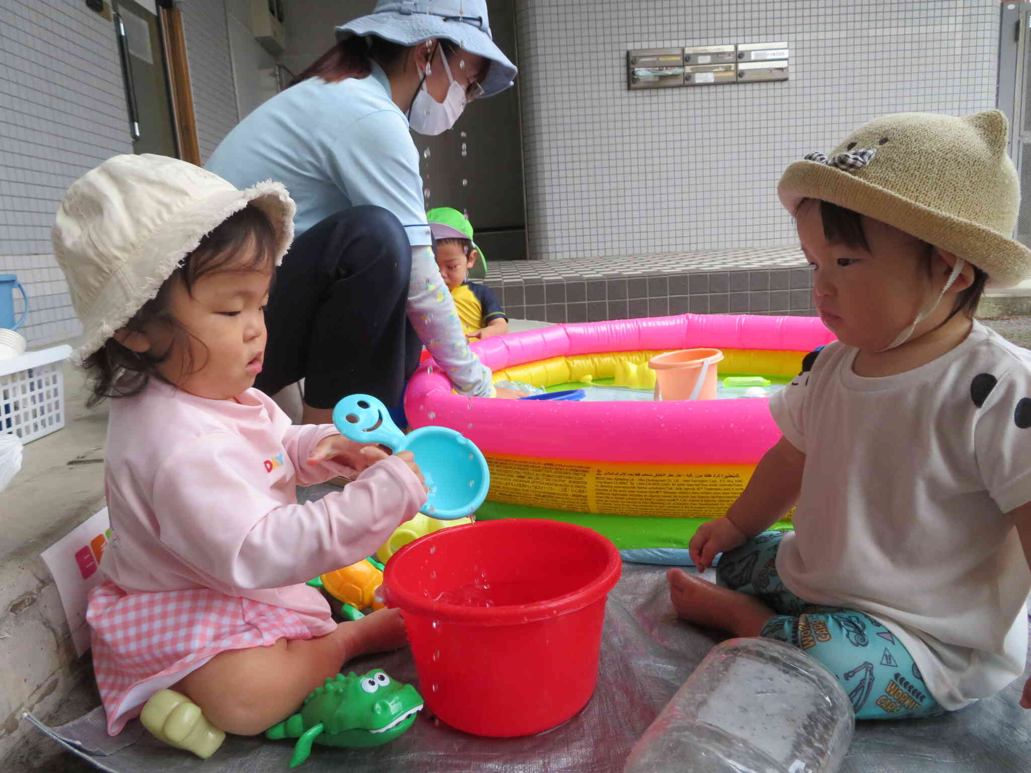 ひよこ組のお友達もお気に入りの水遊びグッズを持って水の感触を楽しんでいます！
