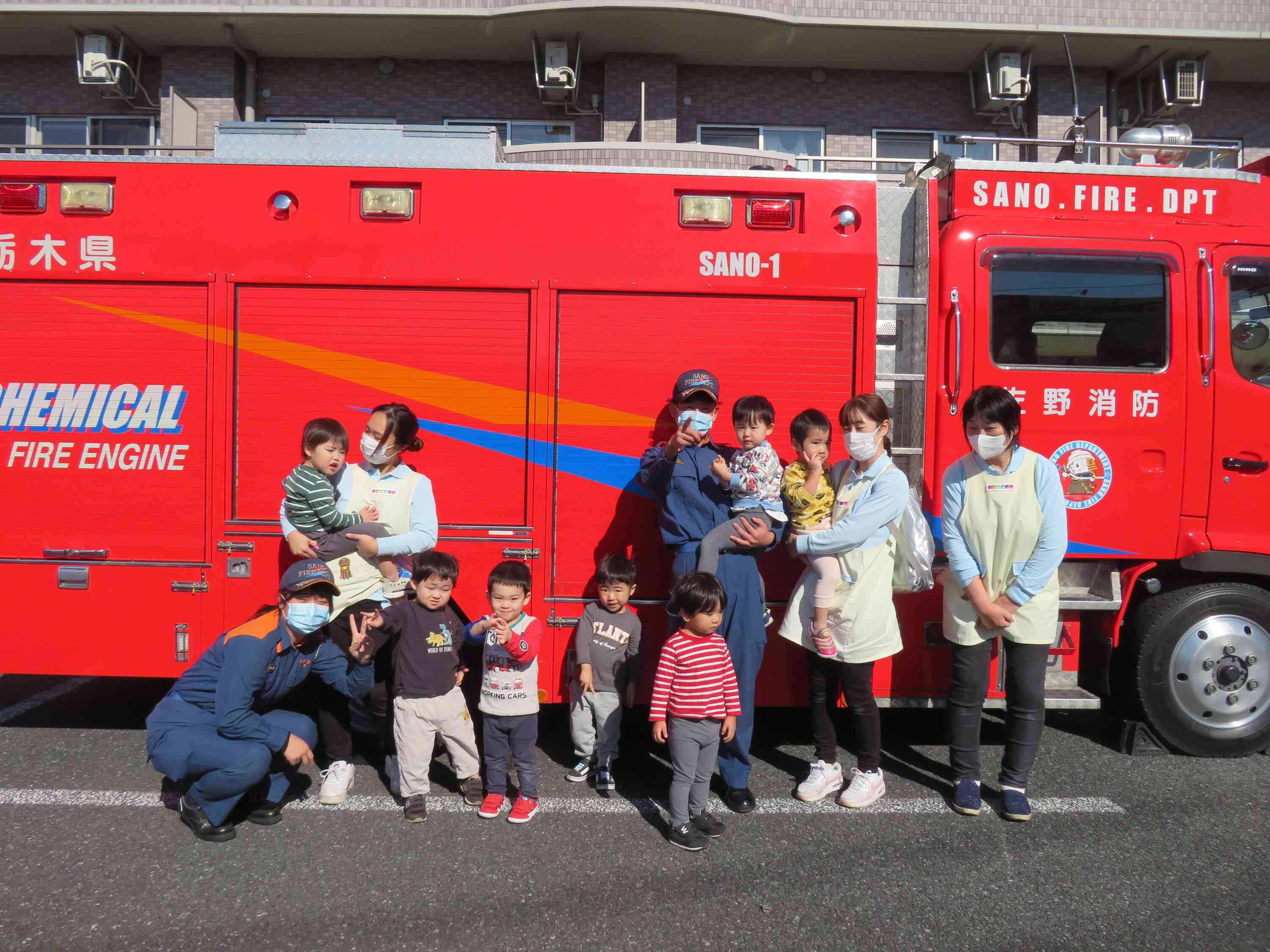 2歳児クラスのお友だちです。消防士さんと一緒にハイチーズ！