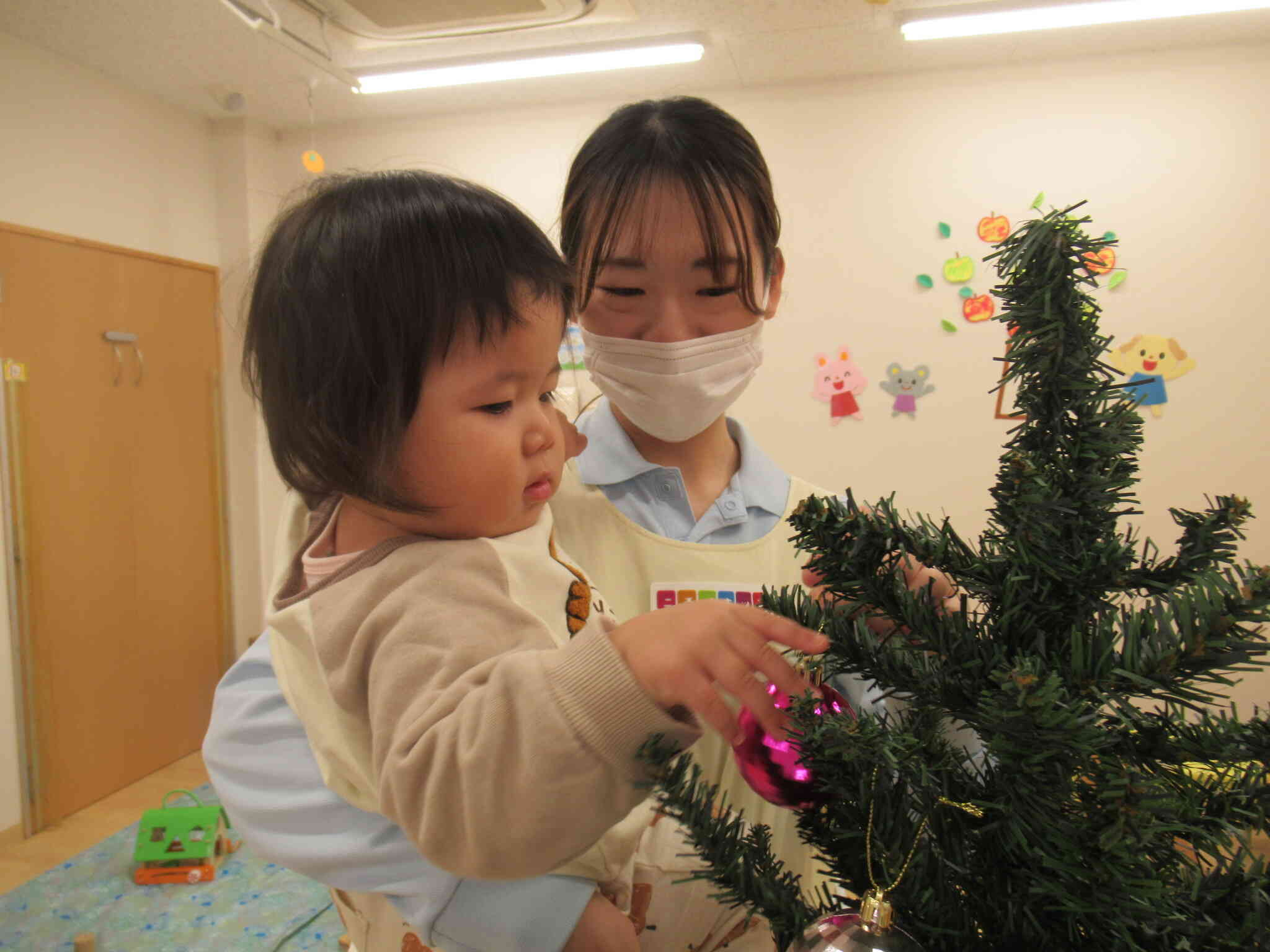 仕上げは０歳児クラスのお友だち。保育士と一緒に飾って完成です！